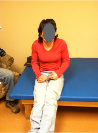 A female sitting on a therapy table with both hands in her lap as an example of a hands-free sitter