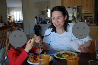 Mother helping child to eat at the table