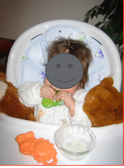Child in high chair chewing on teething toy