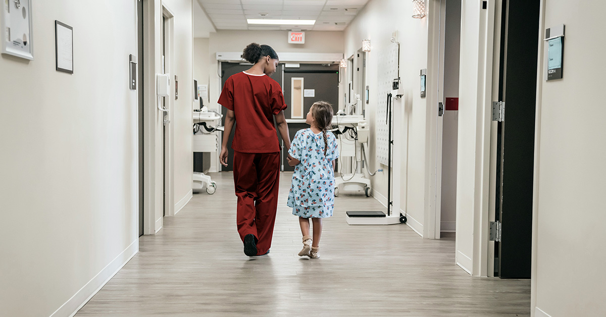 Therapist walking down the hallway with a child patient