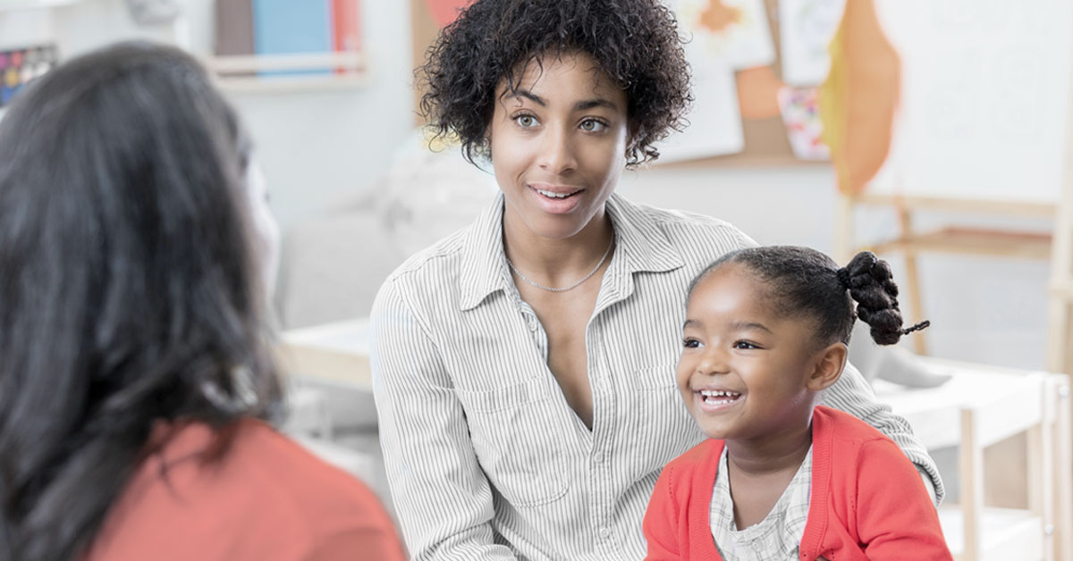 A mother and young child sitting with a therapist