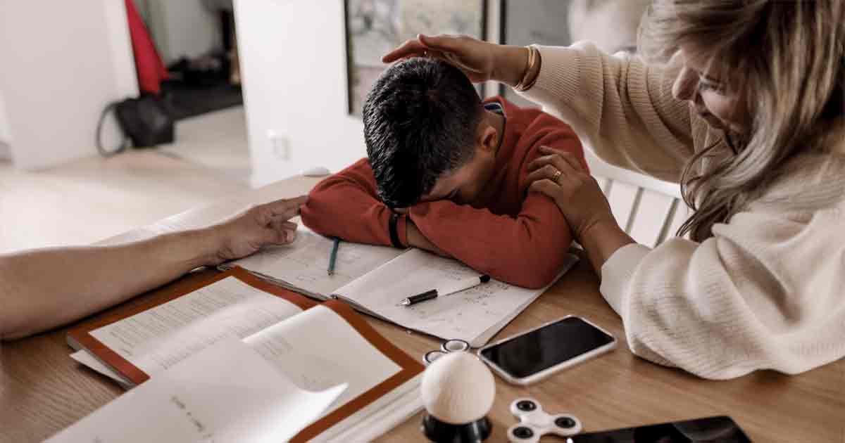 Student with their head resting on school work in frustration 